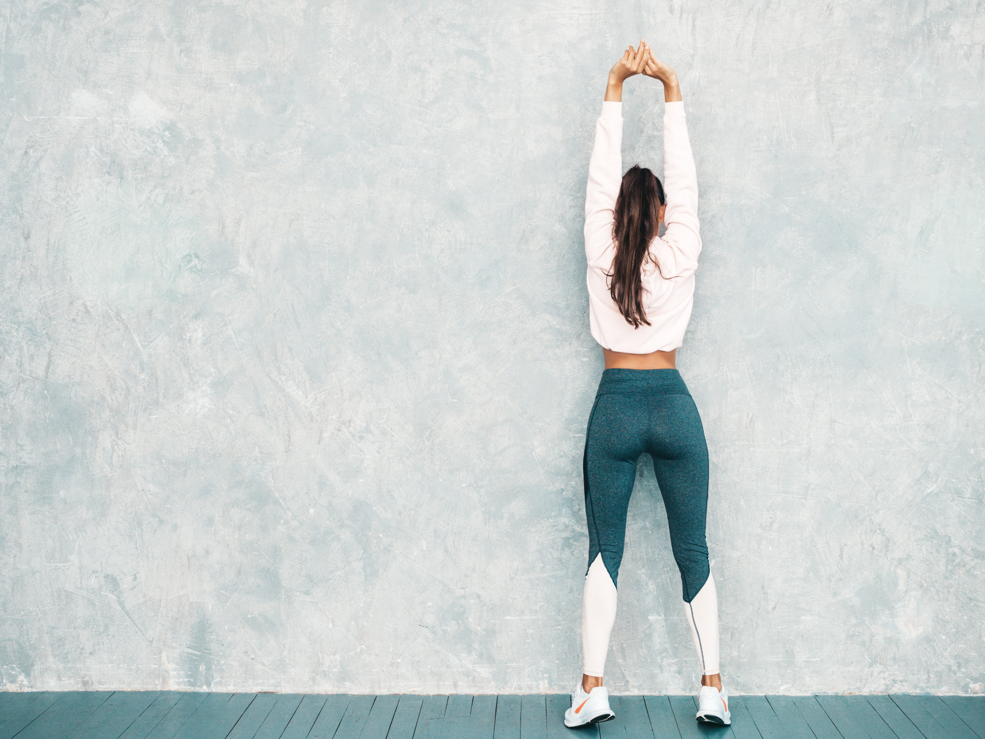 Back View Fitness Woman Sports Clothing Looking Confident Female Stretching Out Before Training Near Gray Wall Studio